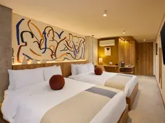 Suite Doble con dos camas dobles bajo un mural de trazos azules y ocres