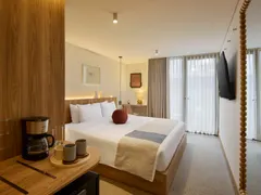 Suite King con cama King, cafetera y espejo de madera junto a la ventana