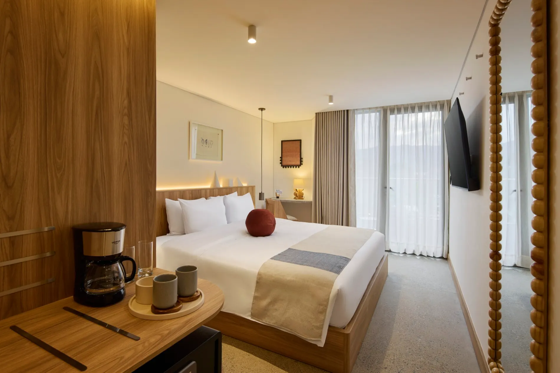 Suite King con cama King, cafetera y espejo de madera junto a la ventana